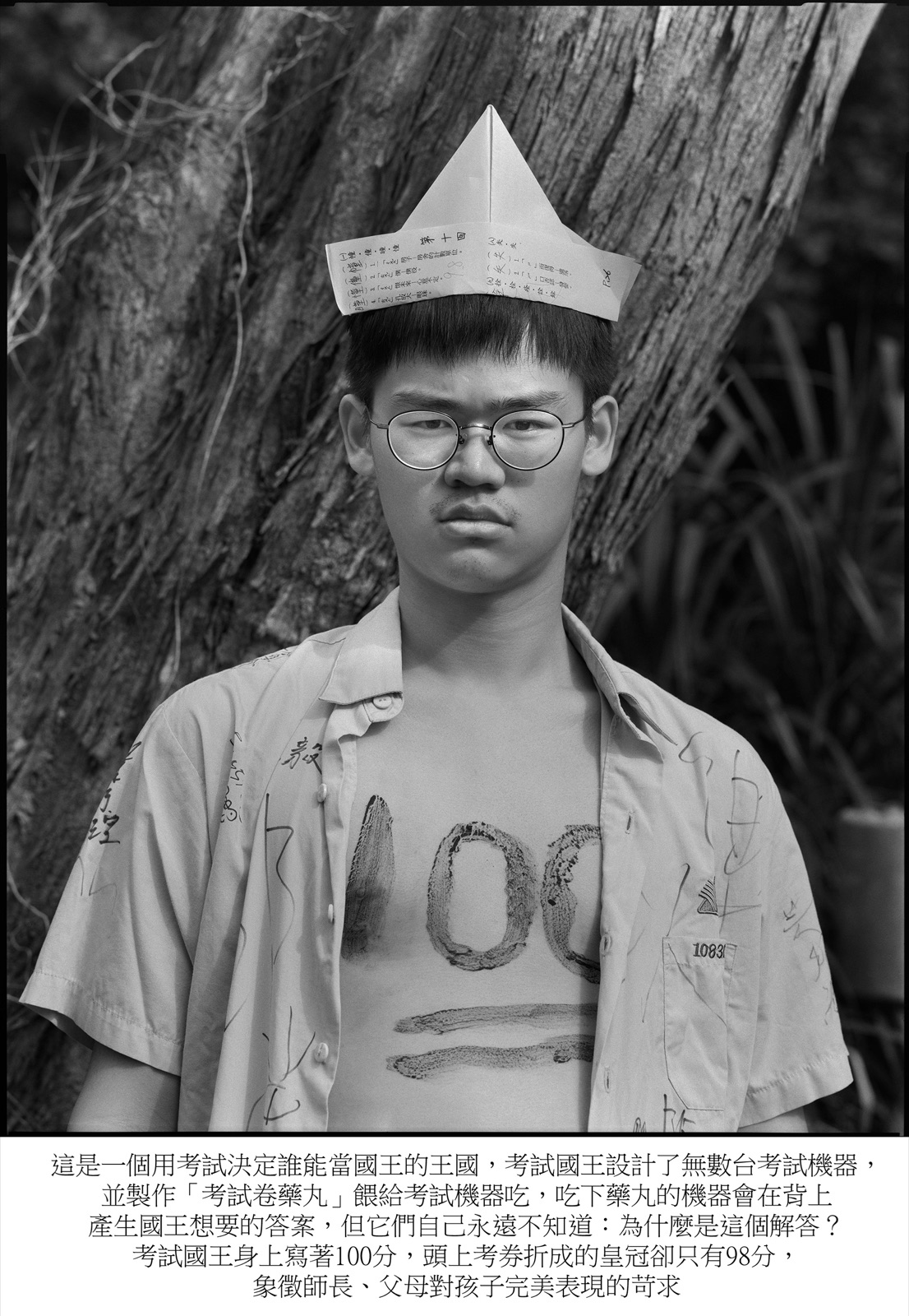 《考試國王 The King of Examination》:戴紙摺皇冠、胸前寫著「100」的黑白全身像,配文講述「考試國王」的寓言。